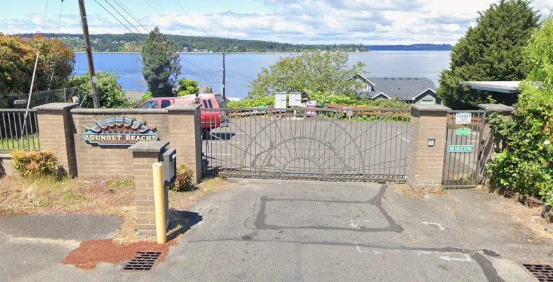 A 50 foot wide HOA-style gate blocking access to Sunset Beach. It says "residents only", "no soliciting", and warns of surveillance.